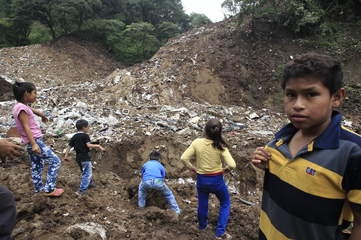 Varios niños que viven en el asentamiento Dios es Fiel bajo el puente el Naranjo, cerca del vertedero clandestino. (Foto Prensa Libre: Carlos Hernández)