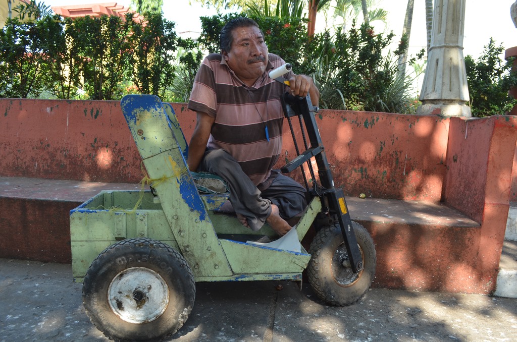 Marvin Manfredo López se moviliza por las calles de la cabecera de Retalhuleu en un carrito de madera que le diseñó un vecino. (Foto Prensa Libre: Jorge Tizol)