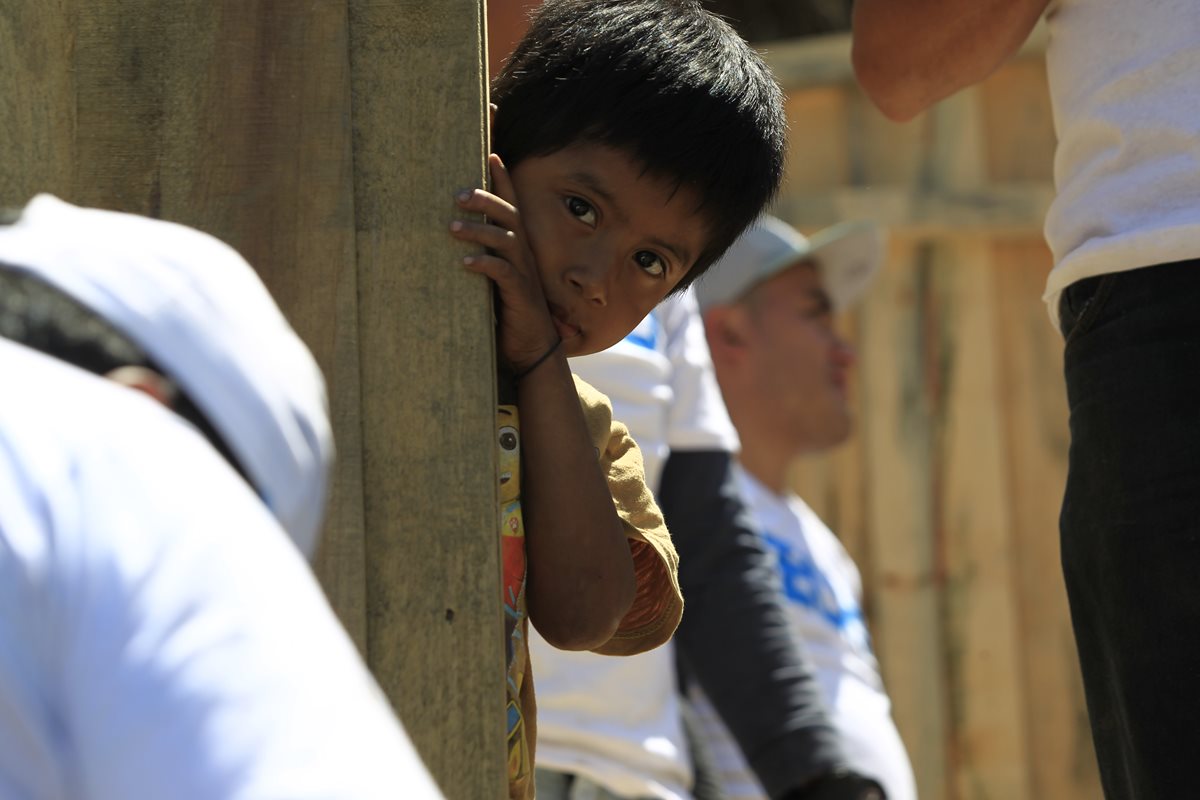 Un niño de una familia beneficiada observa cómo los voluntarios construyen una vivienda. (Foto Prensa Libre: Carlos Hernández)