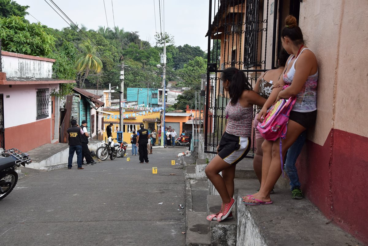 Vecinos observan a las autoridades recoger evidencia en el lugar del ataque. (Foto Prensa Libre: Carlos Enrique Paredes)