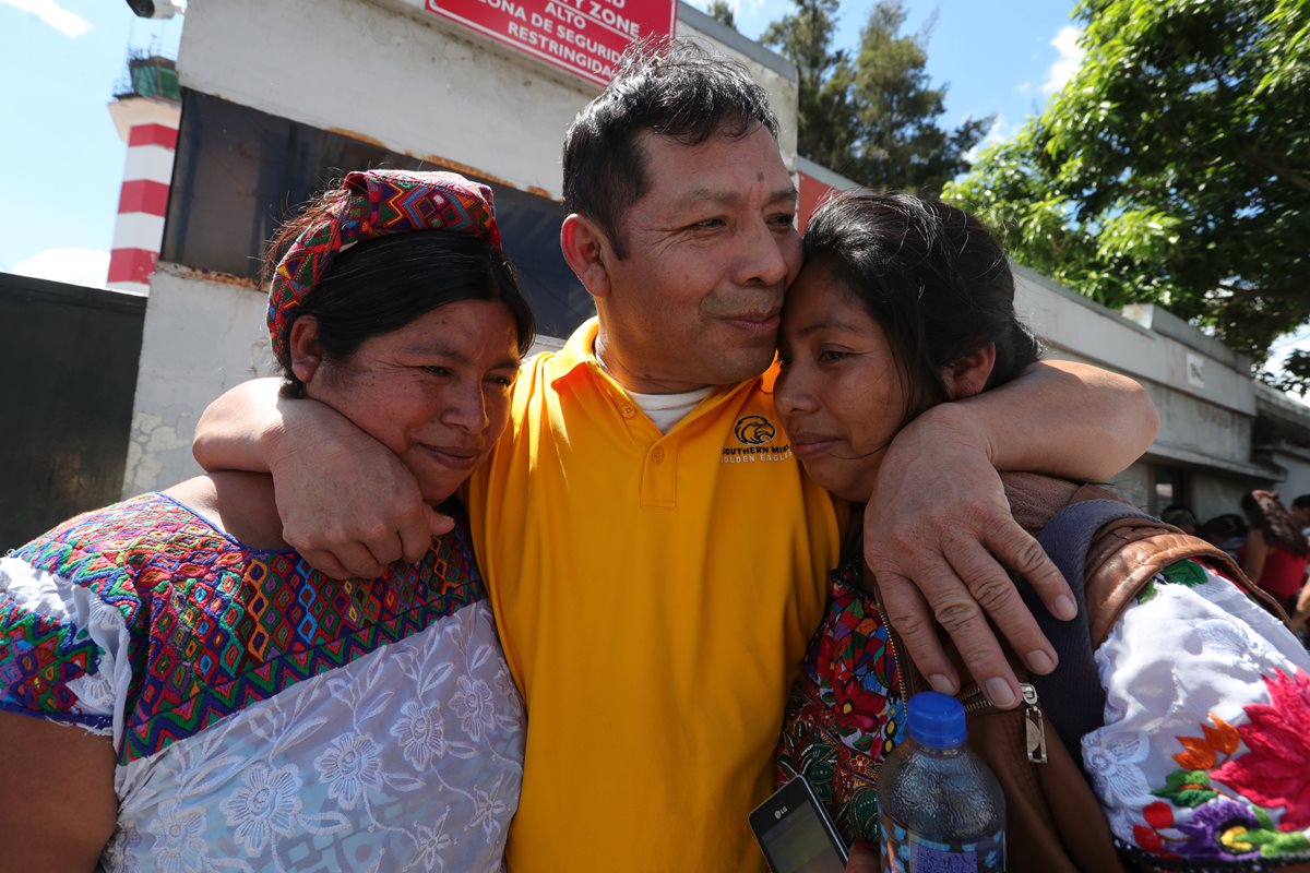 Luis Mejía, deportado que tenía 20 años de vivir en EE. UU. abraza a su esposa y su hija al salir de la Fuerza Aérea Guatemalteca. (Foto Prensa Libre: Estuardo Paredes)