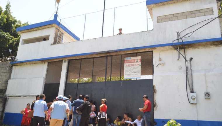 Algunas personas permanecen en el ingreso a la cárcel de El Boquerón, con la intención de dejar alimentos a los internos. (Foto Prensa Libre: Oswaldo Cardona).