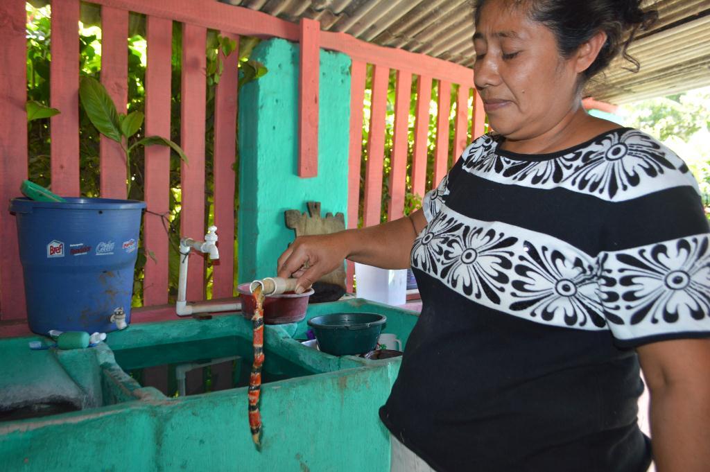 Vecina muestra una de las serpientes localizadas en una tubería. (Foto Prensa Libre: Oswaldo Cardona).