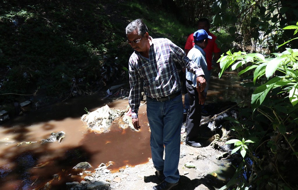 Un vecino observa el río de aguas servidas teñido de café, en la colonia Minerva, zona 2, Huehuetenango. (Foto Prensa Libre: Mike Castillo)