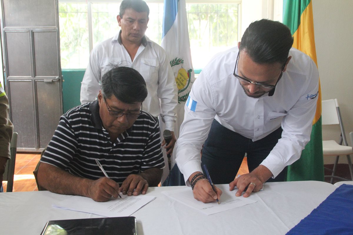 El diputado suplente al Parlamento Centroamericano, Felipe Sac y uno de los representantes de Energuate firman el convenio. (Foto Prensa Libre: Ángel Julajuj)