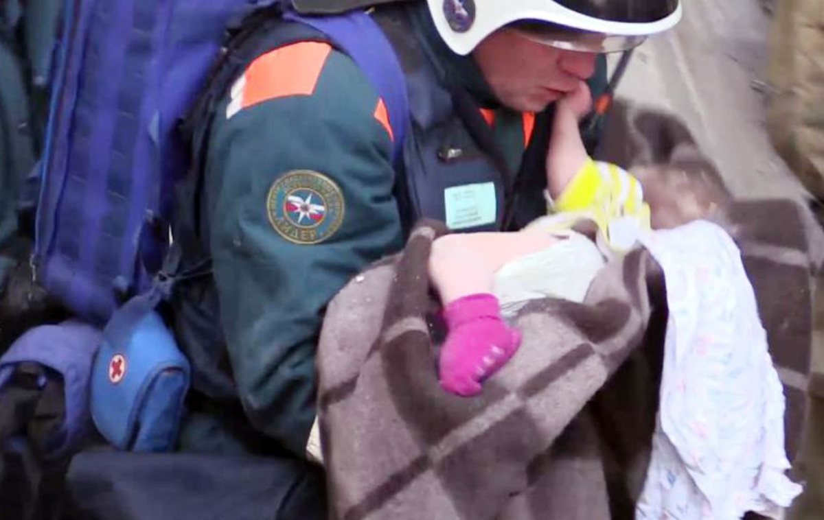 Oficiales de emergencia que transportan a un bebé sobreviviente después de una explosión de gas que sacudió un edificio residencial en la ciudad de los Urales, en Rusia, en Magnitogorsk. (Foto Prensa Libre: AFP