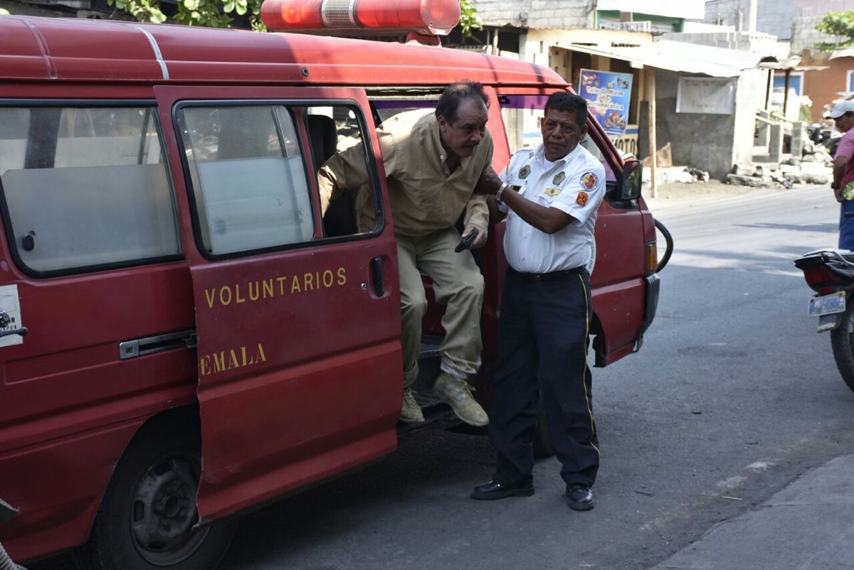 Bomberos Voluntarios trasladan a un hospital al piloto de una avioneta accidentada en Masagua, Escuintla. (Foto Prensa Libre: Carlos E. Paredes)