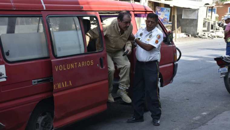 Bomberos Voluntarios trasladan a un hospital al piloto de una avioneta accidentada en Masagua, Escuintla. (Foto Prensa Libre: Carlos E. Paredes)