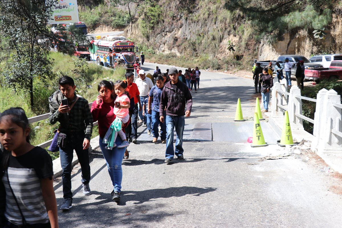 Los pasajeros de los buses extraurbanos son obligados a bajarse de las unidades para pasar a pie sobre el puente. (Foto: Prensa Libre: Héctor Cordero).
