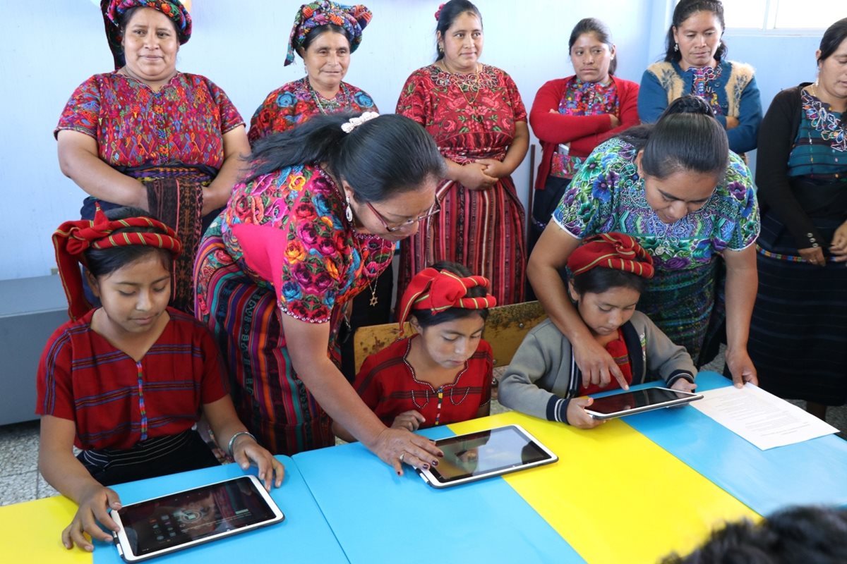 Maestras y madres de familia de la escuela del caserío Los Díaz observan junto a los niños las tabletas donadas. (Foto Prensa Libre: María José Longo)
