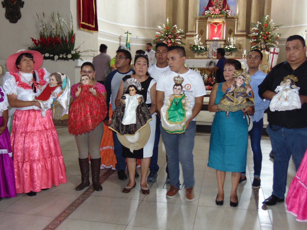 Peregrinos llevan hacia la parroquia de San Juan Bautista de Amatitlán las imágenes de niños visitantes, como parte de la celebración de la Feria en honor de la Santa Cruz.(Foto Prensa Libre: Cortesía)