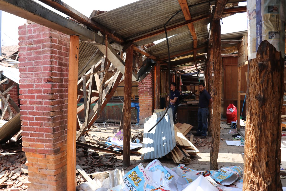 Dos personas observan parte de los escombros que quedaron en el mercado de Santa Cruz del Quiché. (Foto Prensa Libre: Héctor Cordero).