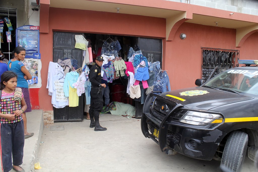 Vecinos de la cabecera de Jalapa y un agente policial observan cadáver baleado de mujer. (Foto Prensa Libre: Hugo Oliva)