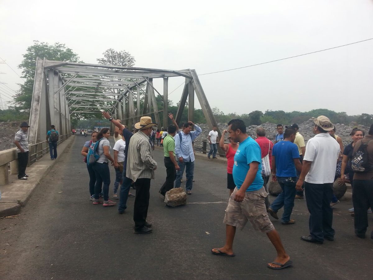 Grupo de maestros impiden paso de vehículos en puente Castillo Armas, Santa Cruz Muluá, Retalhuleu. (Foto Prensa Libre: Rolando Miranda)