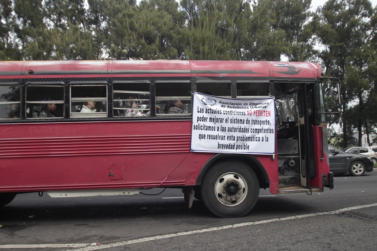 Buses de transporte urbano circulan con mantas en las que se exige el pago del subsidio de parte del Gobierno. (Foto Prensa Libre: Hemeroteca PL)