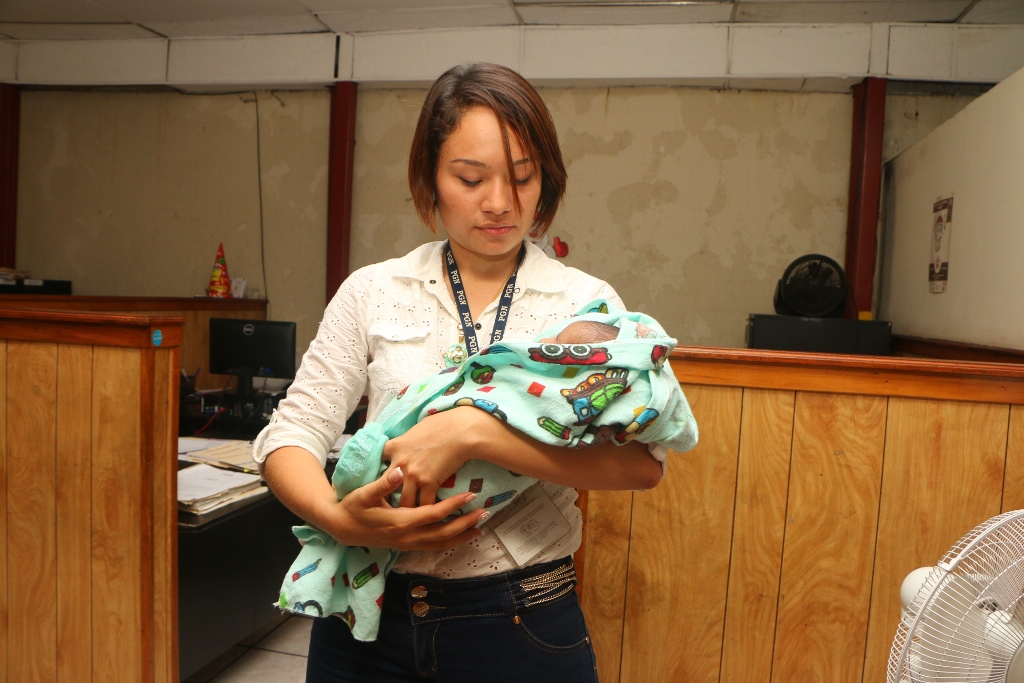 Ana Sandoval, trabajadora de la PGN, carga a le bebé rescatada en Retalhuleu. (Foto Prensa Libre: Rolando Miranda).