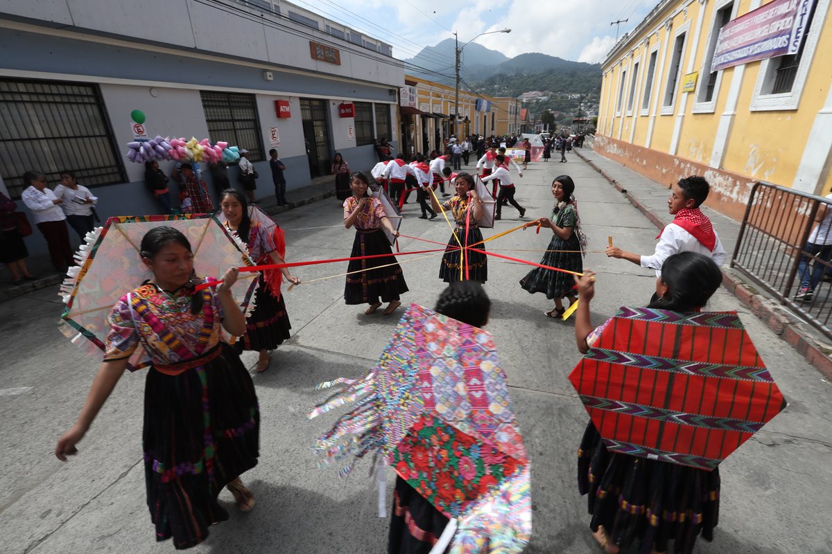 Un grupo de estudiantes que participa en  la caminata intercultural baila la melodía en marimba el barrilete. (Foto Prensa Libre: Mynor Toc) 