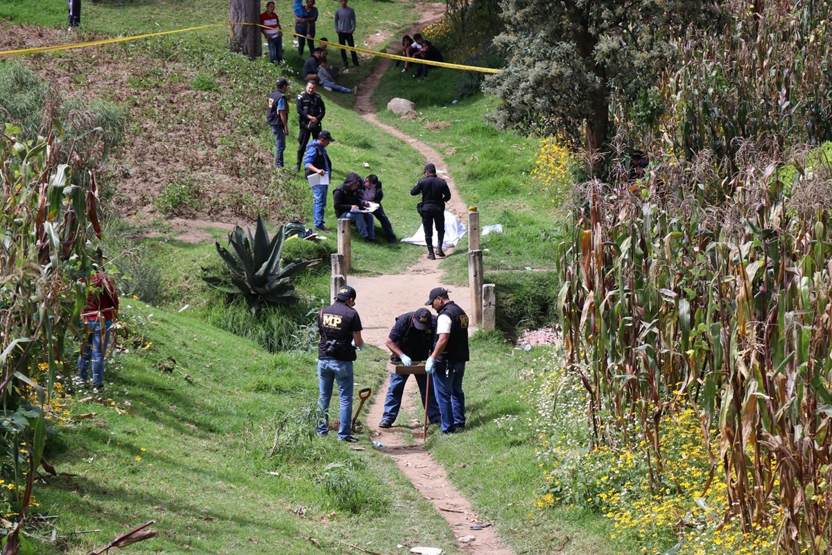 Personal del MP buscó evidencias en la tierra para determinar si el joven fue ultimado en el lugar donde encontraron el cadáver. (Foto Prensa Libre: María Longo)
