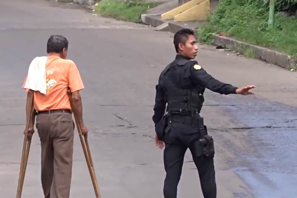 Un hombre es auxiliado por un agente de la PNC en la cabecera de Retalhuleu. (Foto Prensa Libre: Canal 46)