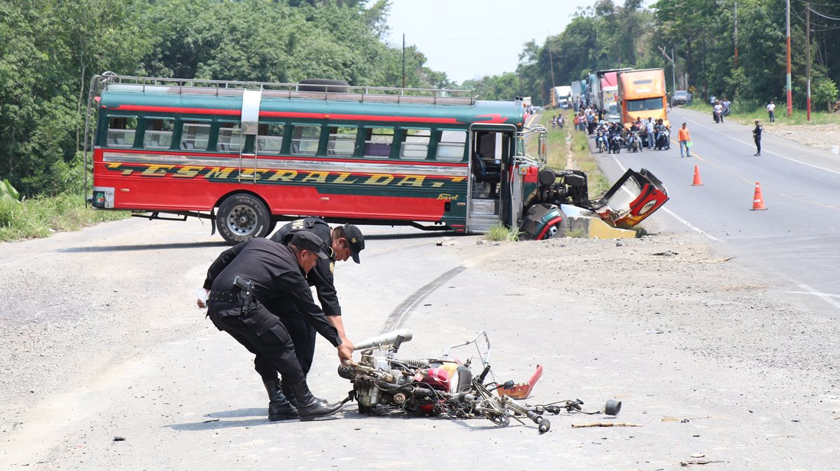 Agentes de la Policía Nacional Civil retiran la motocicleta de Rogers Miranda Santizo, quien murió al colisionar en contra de un bus extraurbano. (Foto Prensa Libre: Cristian Icó Soto)