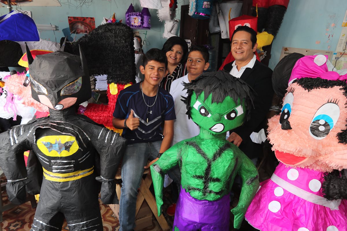 La familia Ortiz Zelaya junto a algunas de las piñatas que fabrican en la zona 1 de la capital. (Foto Prensa Libre: Érick Ávila).