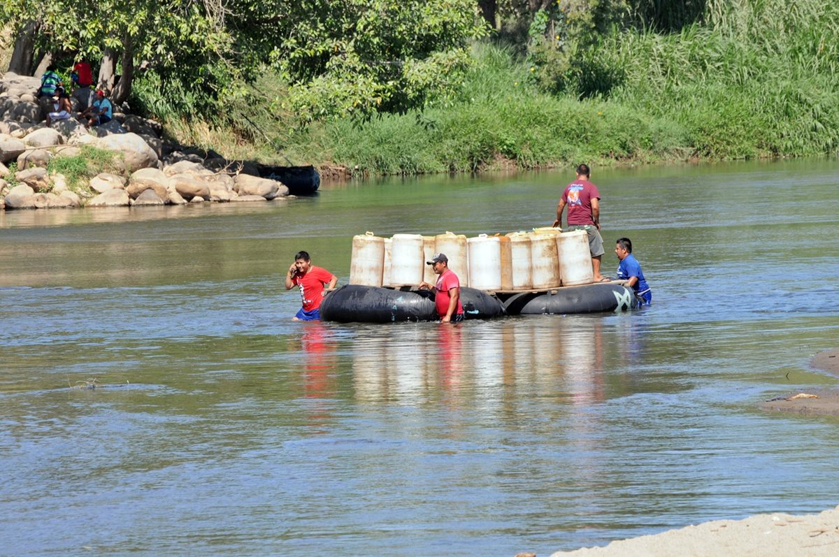 Una balsa transportando recipientes con combustible atraviesa el Suchiate hacia territorio mexicano. (Foto Prensa Libre: Alexander Coyoy)