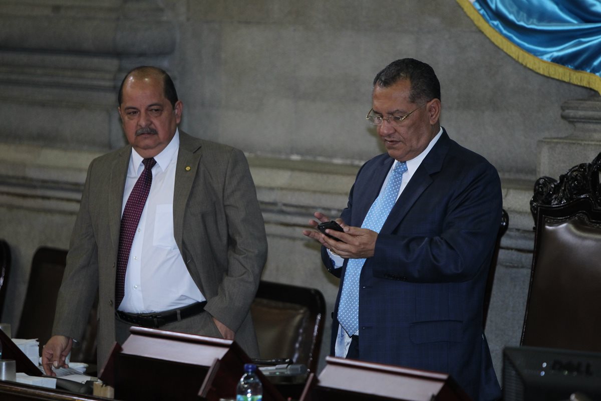 Arístides Crespo -a la derecha- sostiene un teléfono celular, mientras es observado por Alfredo Rabbé. (Foto Prensa Libre: Hemeroteca PL)