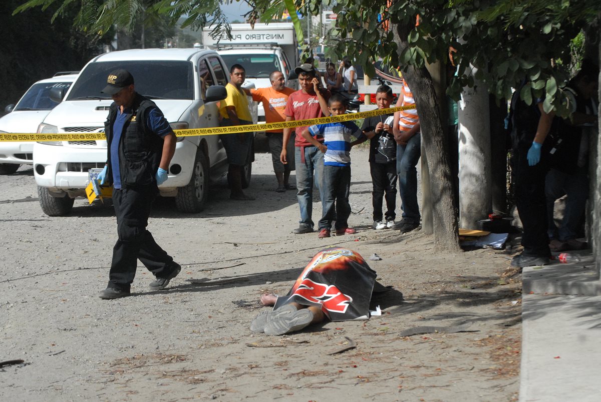 Fiscales del Ministerio Publico procesan la escena del crimen en la aldea Agua Salobrega, Sanarate, donde fue asesinado un vendedor ambulante. (Foto Prensa Libre: Hugo Oliva)