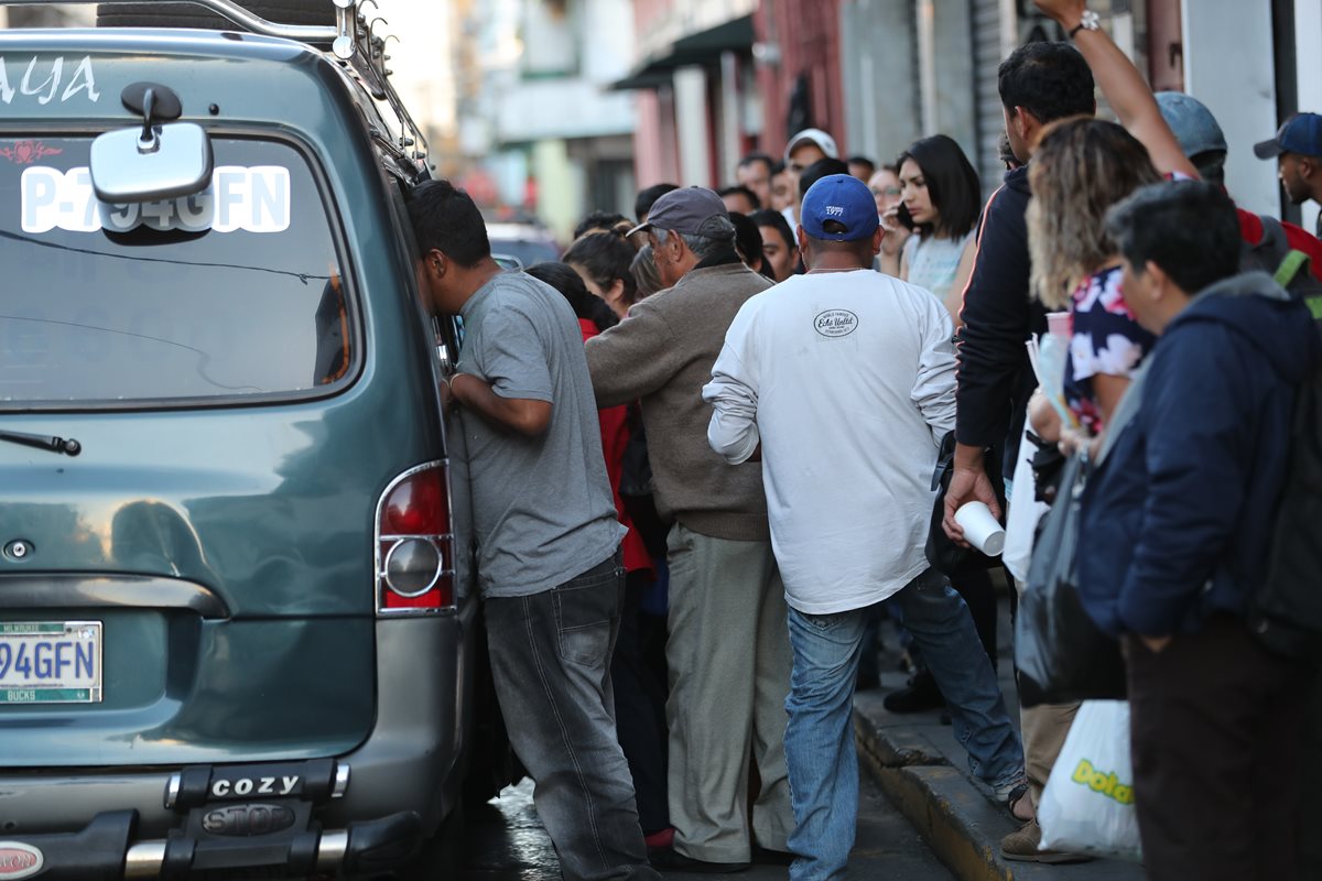 Ayudante del microbús ordena pasajeros en el vehículo ante la demanda para el traslado a la zona 18. (Foto Prensa Libre: Érick Ávila)