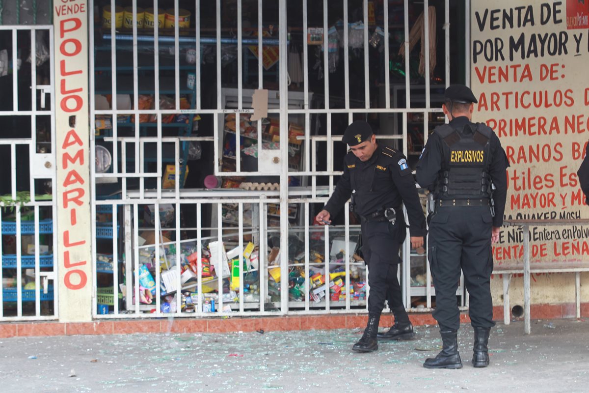 Policías observan indicios en la escena de la explosión. (Foto Prensa Libre: Estuardo Paredes)