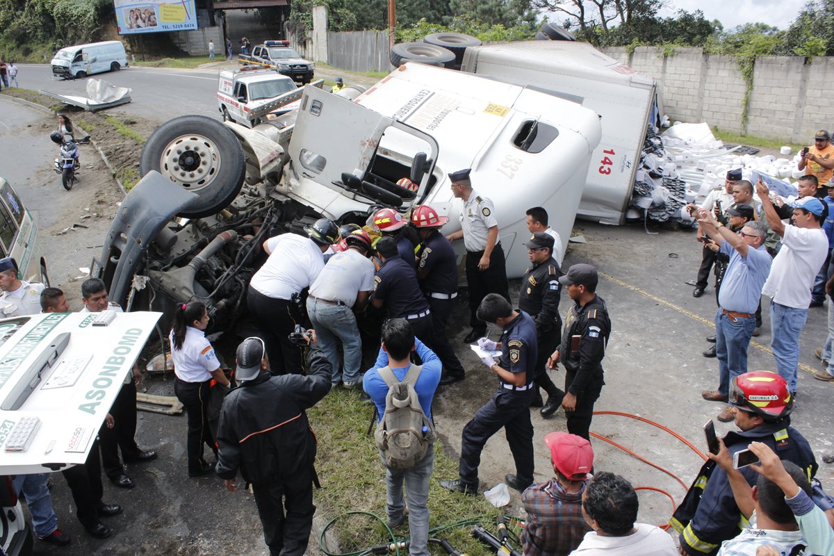 Bomberos rescatan a piloto de tráiler accidentado. (Foto Prensa Libre: Víctor Chamalé).