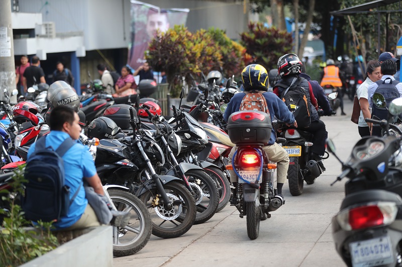 Motoristas transitan en el paso peatonal frente un edificio académico y en espacios peatonales, en el campus central de la Usac, zona 12. (Foto Prensa Libre: Erick Ávila)