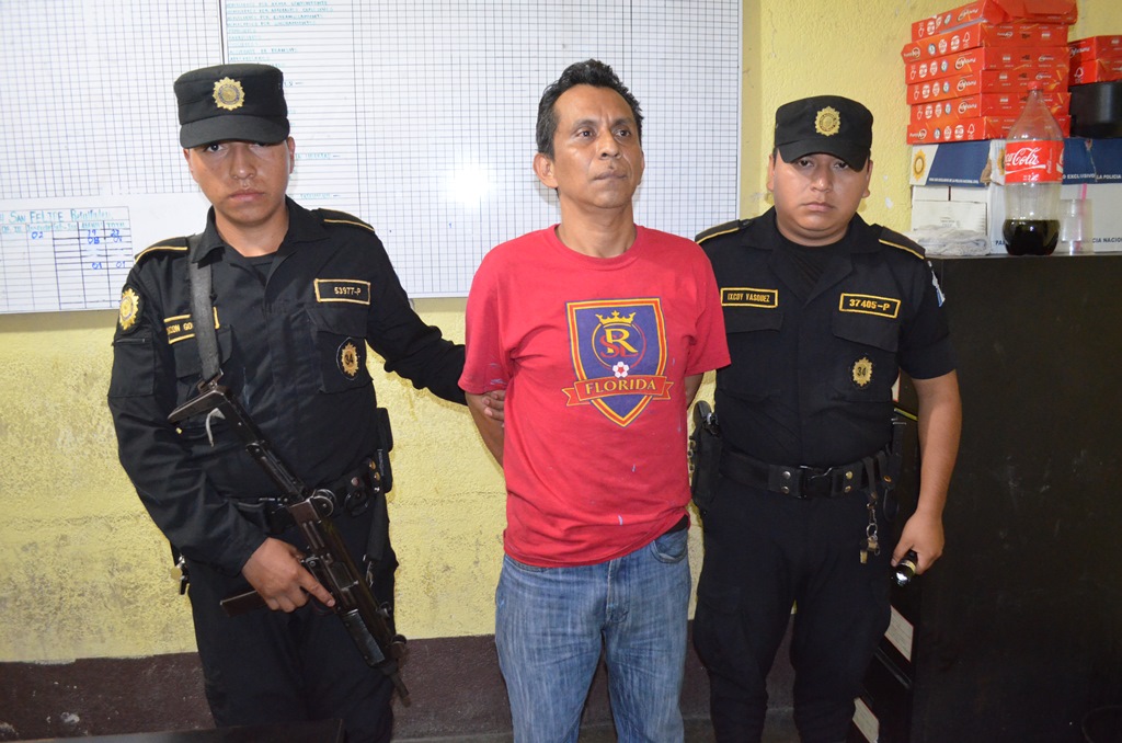 Agentes de la PNC custodian a presunto violador, en San Felipe, Retalhuleu. (Foto Prensa Libre: Jorge Tizol)