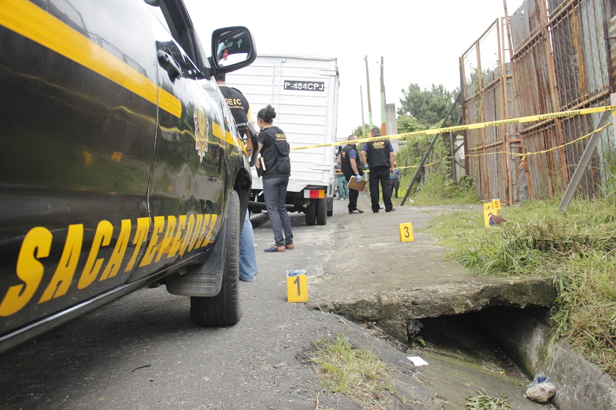 Agentes de la PNC resguardan cadáver de agente de seguridad privada ultimado en Santiago Sacatepéquez. (Foto Prensa Libre: Víctor Chamalé)
