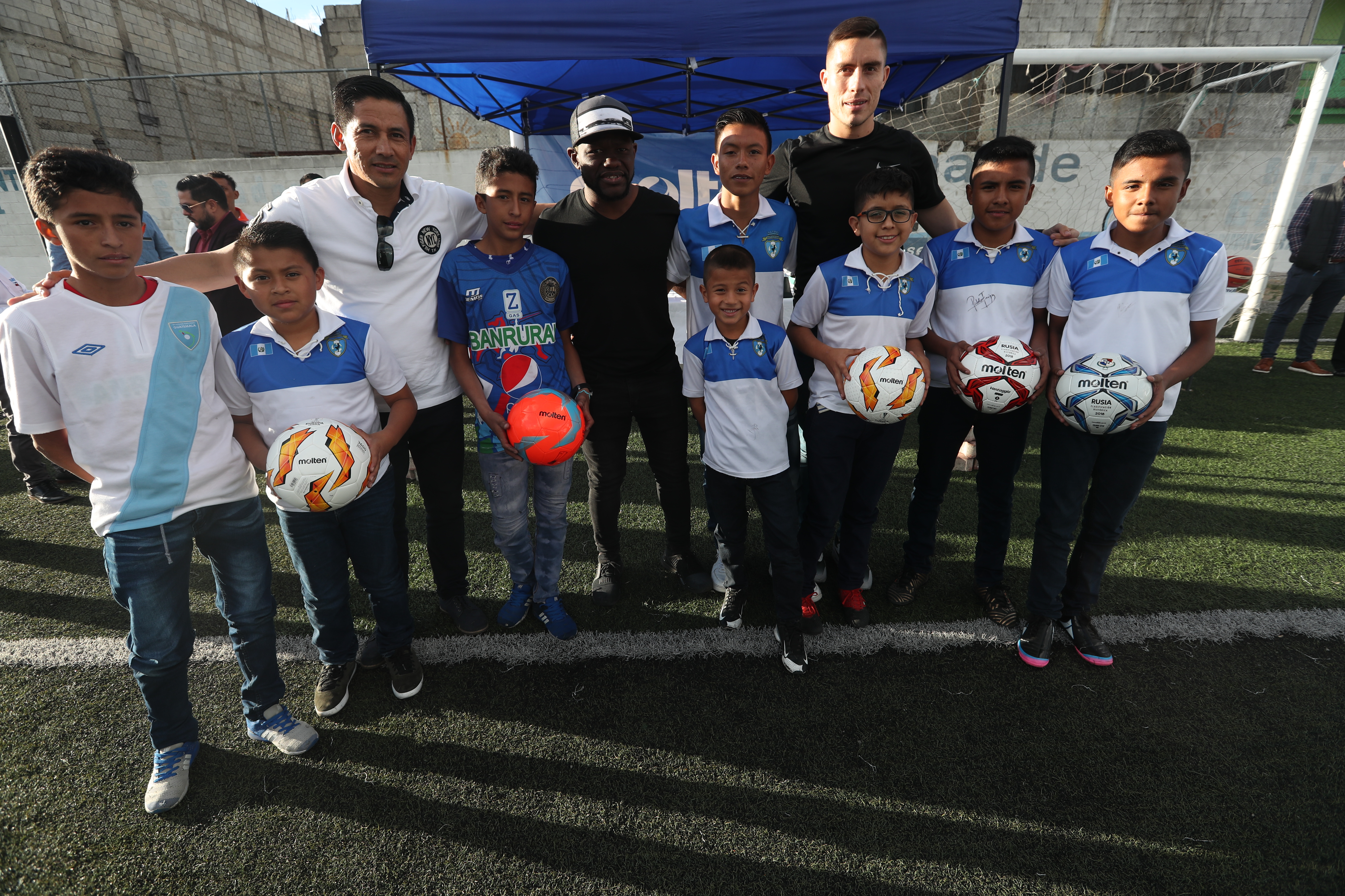 Los futbolistas Elías Enoc Vásquez y Milton Tyson Núñez, y el entrenador Rigoberto Gómez compartieron con niños de Santa Isabel II, zona 3, Villa Nueva (Foto Prensa Libre: Edwin Fajardo)
