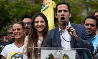 The head of Venezuela's National Assembly and the country's self-proclaimed "acting president" Juan Guaido (R) speaks next to his wife Fabiana Rosales (C) and activist Lilian Tintori (L), wife of Venezuelan opposition leader Leopoldo Lopez, to a crowd of opposition supporters in Caracas, on January 26, 2019. (Photo by Federico PARRA / AFP)