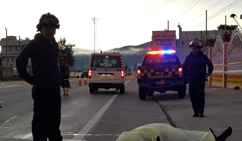 Bomberos observan al agente de la PNC que murió arrollado en la ruta Interamericana. (Foto Prensa Libre: Cortesía). 

