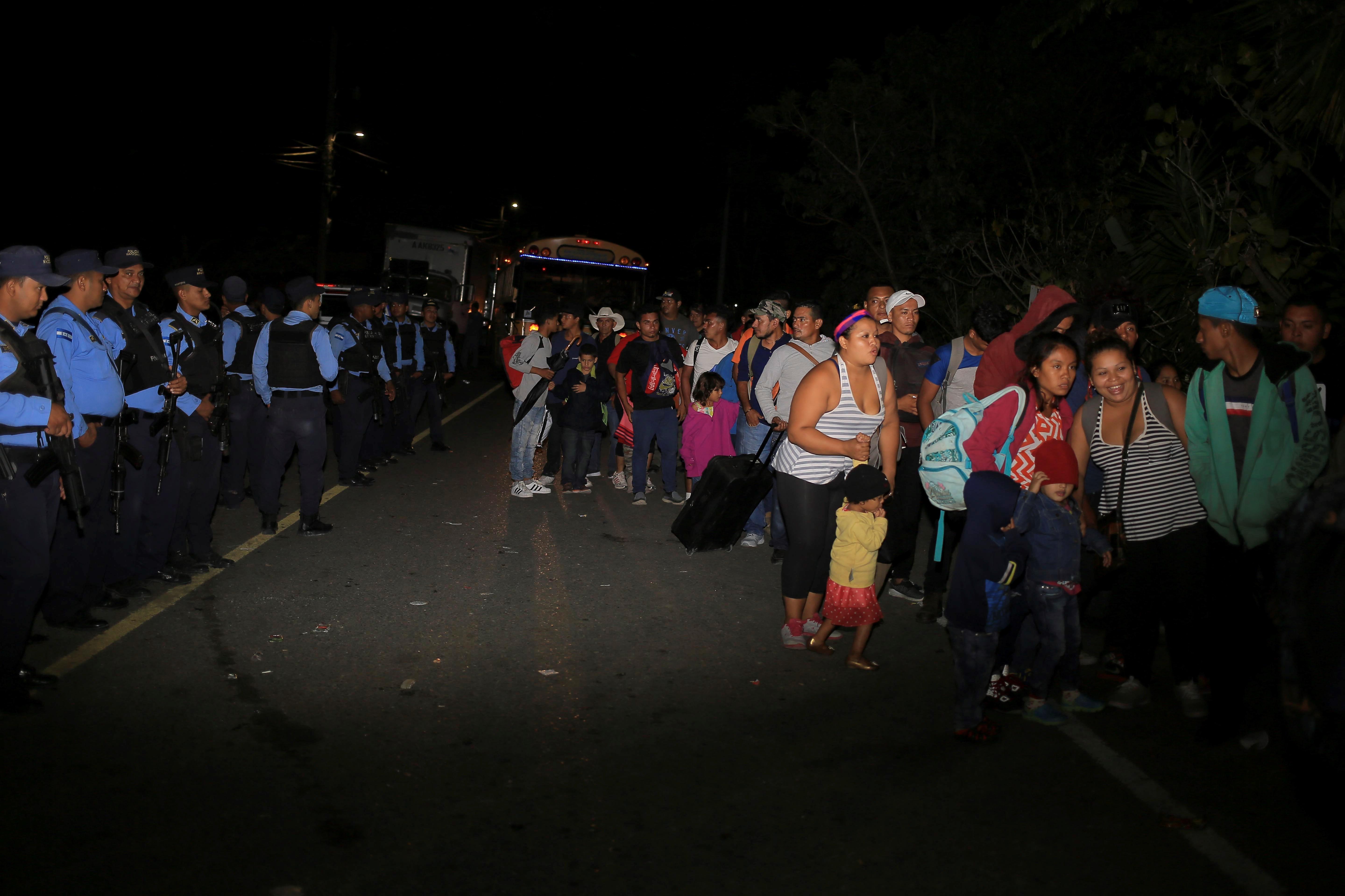 AME8131. AGUA CALIENTE (HONDURAS), 15/01/2019.- Ciudadanos hondureños pasan por un reten policial hoy, en la aduana de Agua Caliente, frontera entre Honduras y Guatemala. Al menos 500 hondureños de la caravana de migrantes que salió el lunes de su país cruzó hoy la frontera con Guatemala, y tiene previsto continuar por el territorio para intentar llegar a Estados Unidos, pudo constatar Efe. Los migrantes hondureños, entre ellos varios menores de edad, pasaron este martes el punto fronterizo de Agua Caliente y se dirigen hacia Esquipulas.EFE/Gustavo Amador