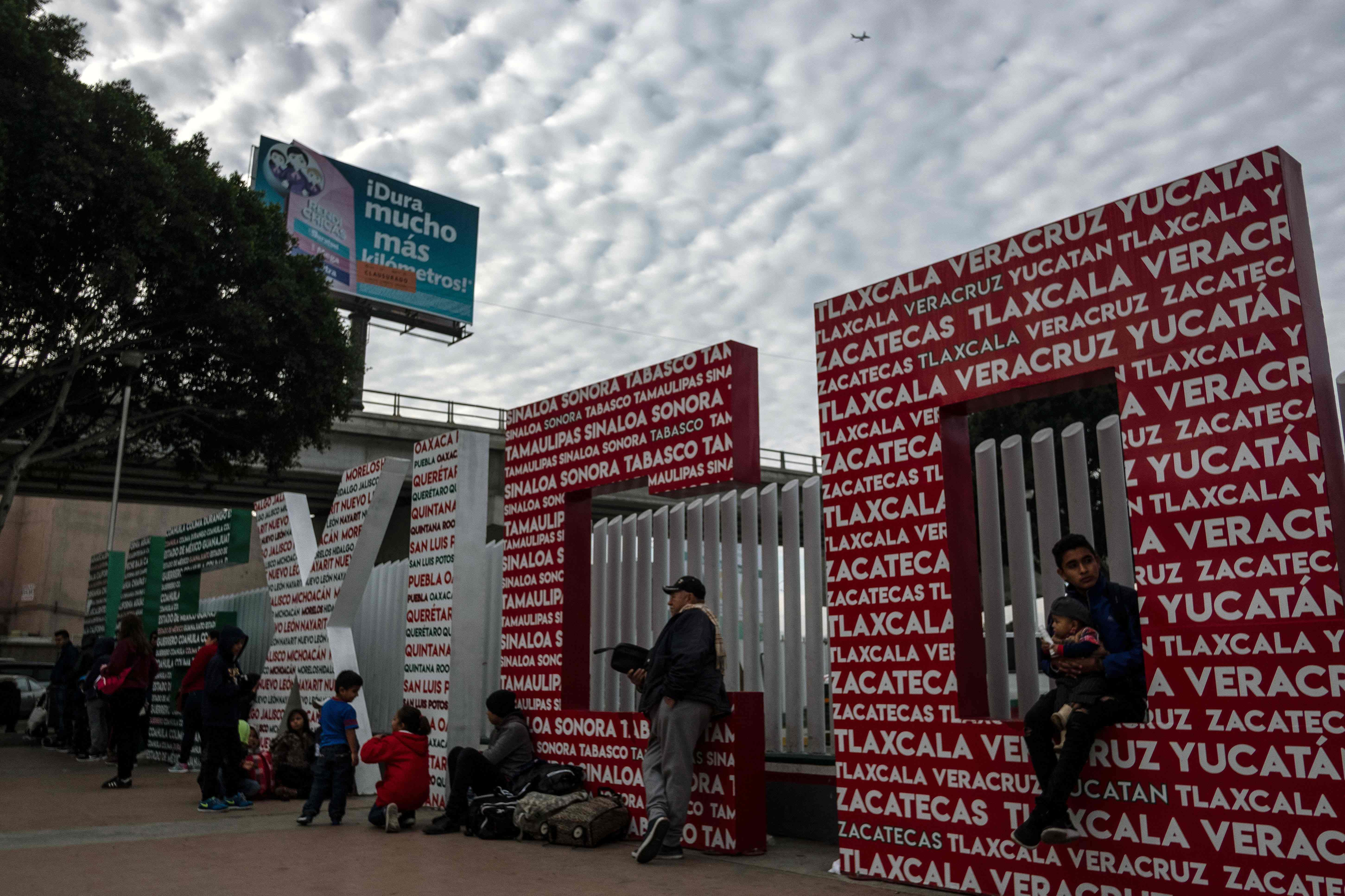 Solicitantes de asilo esperan en El Chaparral, después de cruzar la frontera en Tijuana. (Foto Prensa Libre: AFP)