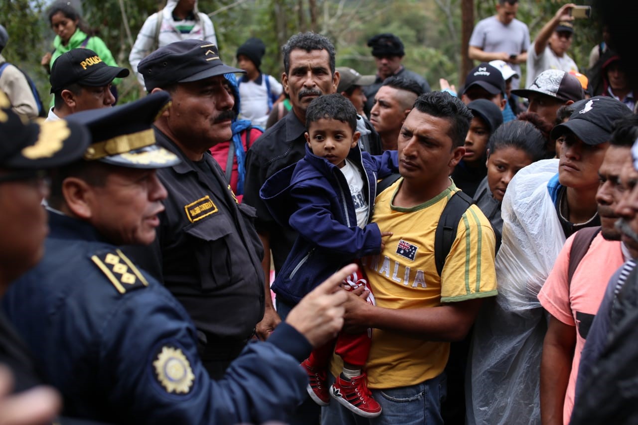 Migrantes hondureños dialogan con agentes de la Policía Nacional Civil antes de registrarse en la aduana de Agua Caliente. (Foto Prensa Libre:  Carlos Hernández) 
