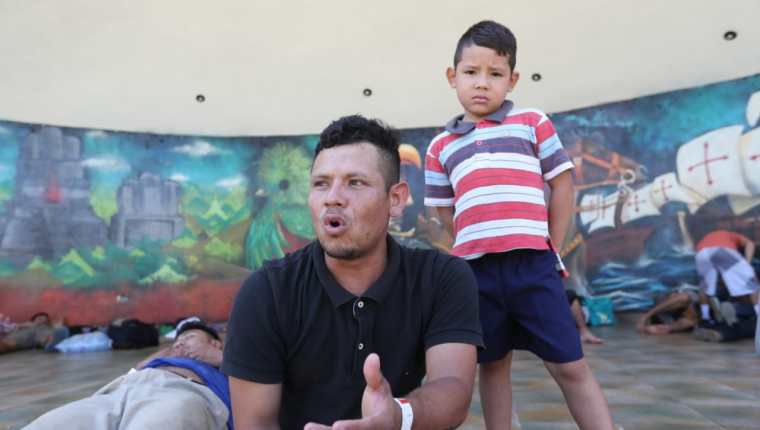 Elmer Alexander Hernández descansa junto a su hijo en la Concha Acústica de Tecún Umán, en San Marcos, frontera con México. (Foto Prensa Libre: Erick Ávila) 