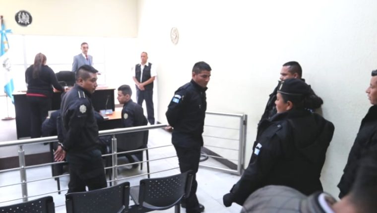 Tres agentes de la PNC salen de la sala de audiencias luego ser enviados al Preventivo de la zona 18, fueron detenidos por "exigir" Q4 mil a un comerciante. (Foto Prensa Libre: Hemeroteca)