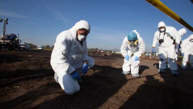 Expertos forenses registran la zona cerca de una toma clandestina de gasolina de Petróleos Mexicanos (Pemex). (Foto Prensa Libre: EFE)