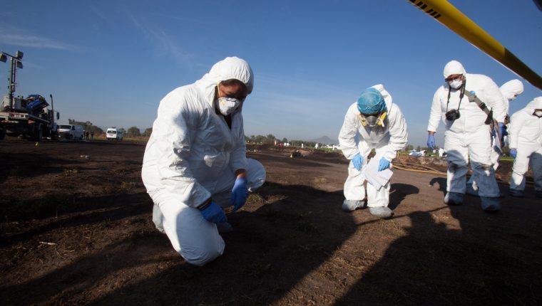 -FOTODELDÍA- AME9819. TLAHUILILPAN (MÉXICO), 18/01/2019.- Expertos forenses registran la zona cerca de una toma clandestina de gasolina de Petróleos Mexicanos (Pemex) que explotó este sábado, en Tlahuililpan, Hidalgo (México). La explosión de una toma clandestina en México suma ya 67 muertos y 75 heridos siendo una de las peores tragedias en décadas y reflejando el problema del robo de hidrocarburos, que el presidente Andrés Manuel López Obrador ha prometido seguir combatiendo. EFE/ MLA