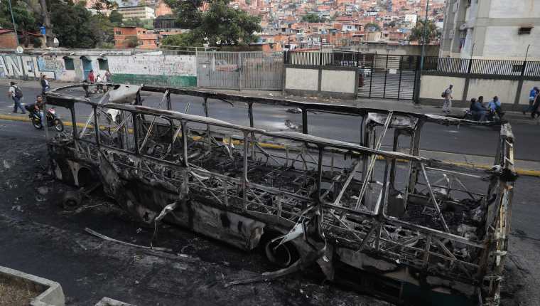 Vista de un autobús incendiado en la madrugada de este miércoles en Caracas. (Foto Prensa Libre: EFE)