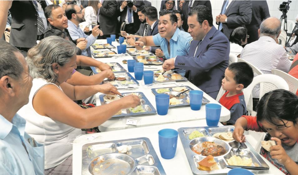 El presidente Jimmy Morales asiste a la inauguración de comedores sociales y se sienta a la mesa para comer con algunos de los beneficiados. Foto: Hemeroteca PL