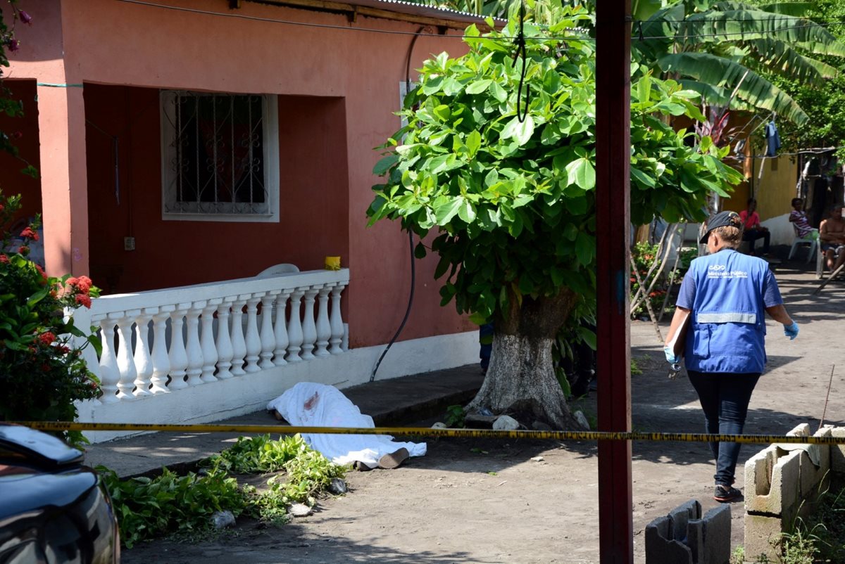 Cadáver de Randolfo Jauregui es acordonado por agentes de la PNC en Puerto San José, Escuintla. (Foto Prensa Libre: Carlos E. Paredes)