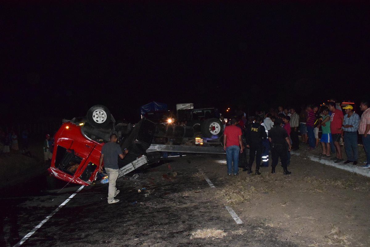 Agentes de la Policía Nacional Civil revisan el lugar del accidente ante los ojos de varios curiosos. (Foto Prensa Libre: Carlos Paredes)