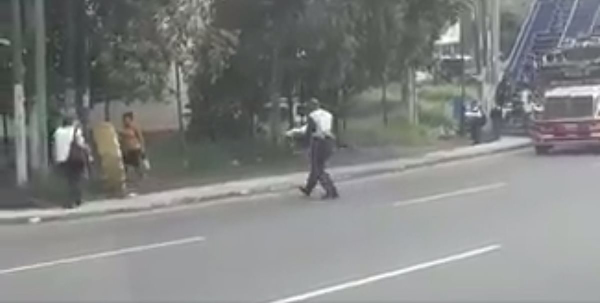 Un perro arrollado es rescatado por un agente de la PMT de Villa Nueva. (Foto Prensa Libre: Twitter Dalia Santos)