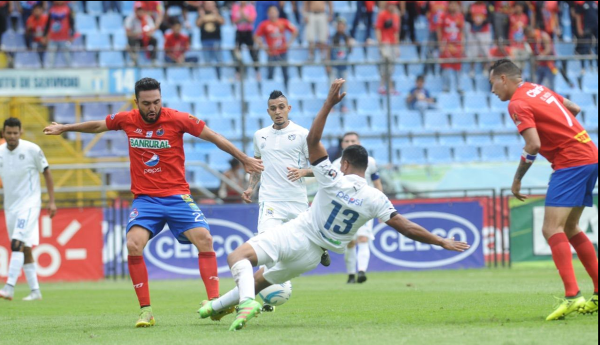 El ariete mexicano Carlos Kamiani Félix, de Municipal, recibe una dura entrada del defensor Carlos Castrillo, de Comunicaciones, durante el Clásico 300 celebrado en el estadio Doroteo Guamuch Flores. (Foto Prensa Libre: Francisco Sánchez)